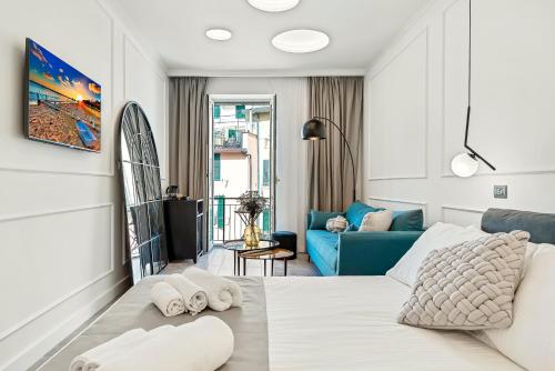 um quarto branco com uma cama e um sofá azul em EC Luxury Rooms em Riomaggiore