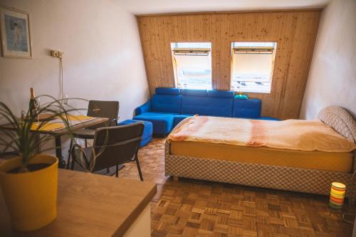 a room with a bed and a couch and a table at Sončni apartma in Bovec