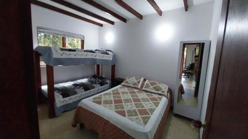 a bedroom with two bunk beds and a mirror at Villa campestre casa blanca in San Pedro