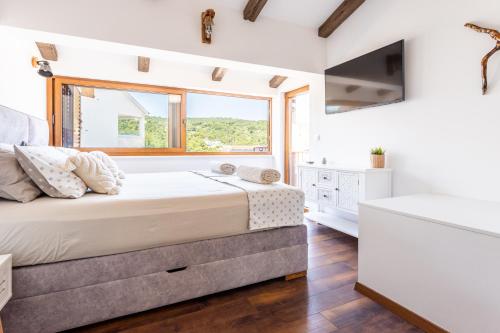 Un dormitorio con una cama grande y una ventana en Šolta Stone House en Stomorska