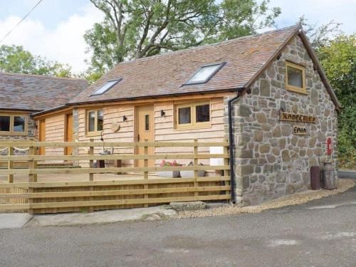 a log cabin with a wooden fence around it at Cosy and quiet one bed barn conversion. in Church Stretton