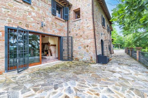 an entrance to a brick building with sliding glass doors at Quercia Close By to Montepulciano - Happy Rentals in Montepulciano