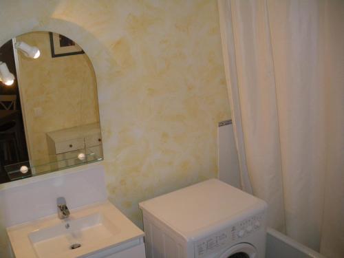ein Badezimmer mit einem Waschbecken und einer Waschmaschine in der Unterkunft Les Bastides in Gréoux-les-Bains