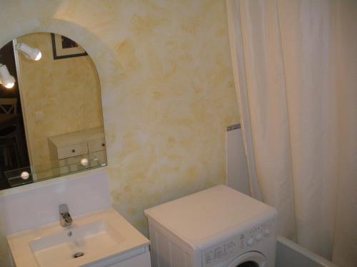 une salle de bain avec un lavabo et une machine à laver dans l'établissement Les Bastides, à Gréoux-les-Bains