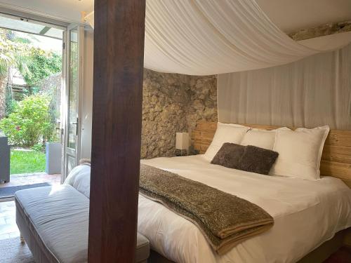 une chambre avec un lit à baldaquin dans l'établissement Le St Vincent, à Roquefort