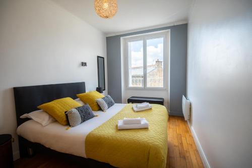 a bedroom with a bed with yellow sheets and a window at Le Kador, appartement avec vue sur mer in Crozon