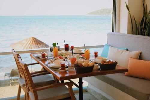a table with food and a view of the ocean at Lavinya Otel in Golturkbuku