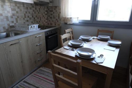 una cocina con una mesa con platos y sartenes. en Δ1 - Τα διαμερίσματα του δασκάλου στα Φιλιατρά, en Filiatra