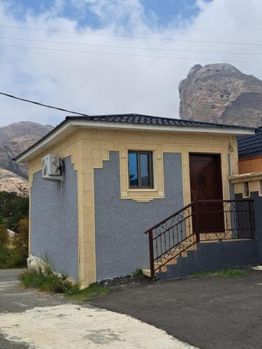 une petite maison avec une porte et une montagne dans l'établissement استوديو ريفي تنومه, à Tanomah