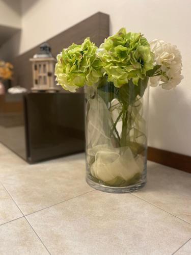 a vase filled with green flowers sitting on a floor at Residence Outlet Vivaldi in Noventa di Piave