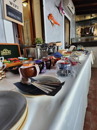 a white table with plates and utensils on it at Ribica Luxury Rooms in Rijeka