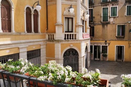 - un bâtiment avec un portail et des fleurs dans une cour dans l'établissement Appartamento Al Malibran, à Venise