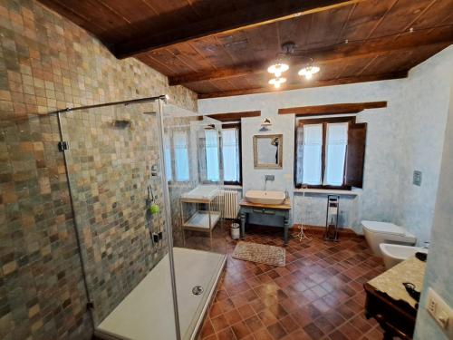 a bathroom with a shower and a toilet and a sink at I Templari - Affittacamere in Castignano