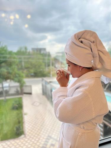 a woman wearing a hijab looking out of a window at Cube House Osh in Osh
