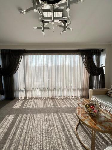 a living room with a couch and a large window at Cube House Osh in Osh