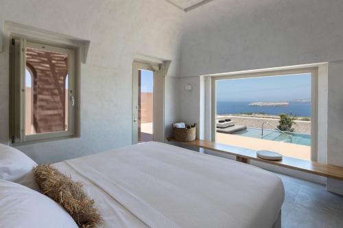 a bedroom with a bed and a view of the ocean at Serra Exclusive Suites in Akrotiri