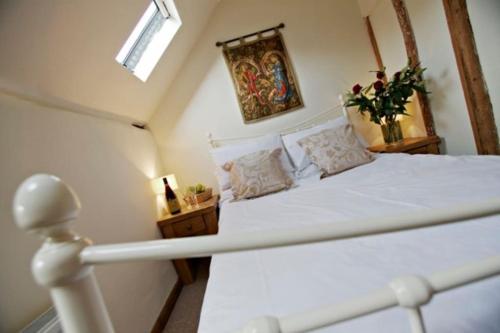 a bedroom with a white bed in a attic at White Horse Cottage with Sauna in Ollerton