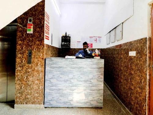 a man standing behind a counter in a building at Collection O 81235 Hotel Aashiyana in New Delhi