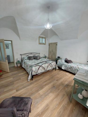 a bedroom with two beds and a wooden floor at I Tre Merli in Dolceacqua