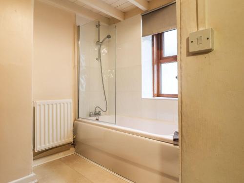 a bathroom with a shower and a bath tub at Cosy seaside town cottage with private garden in Cardigan