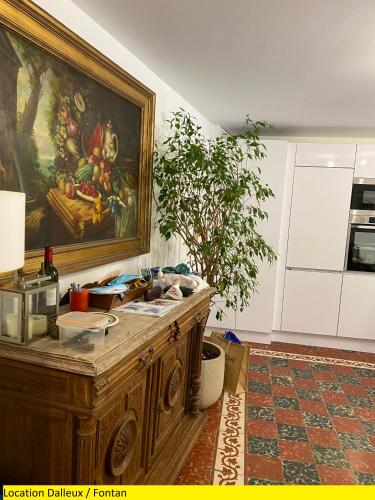 une cuisine avec un tableau sur le mur et une table dans l'établissement Appartement 2 pièces a Fontan - Vallée de la Roya à 2 pas du Mercantour - Location à la semaine - Arrivée et Départ le samedi ou le dimanche seulement, à Fontan