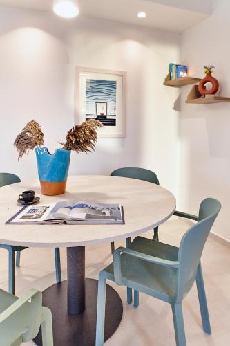 a table and chairs in a dining room with a book on it at Sigma Residences Boutique Hotel in Exámbela