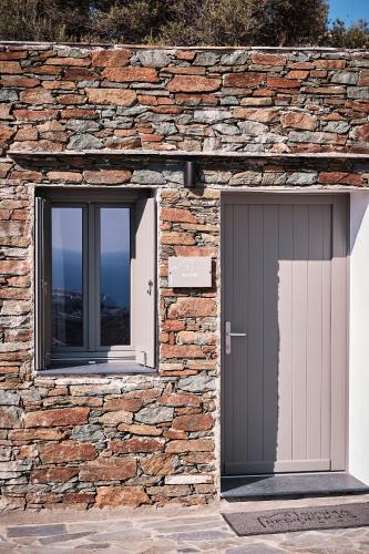 a stone building with two doors and two windows at Sigma Residences Boutique Hotel in Exámbela