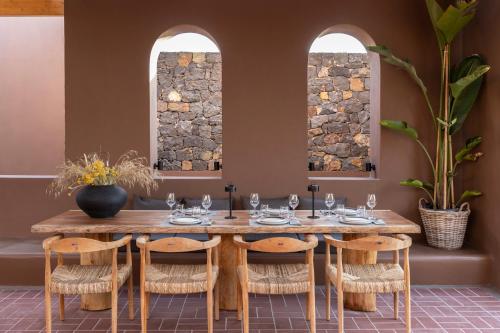 a dining room with a wooden table and chairs at Serra Exclusive Suites in Akrotiri