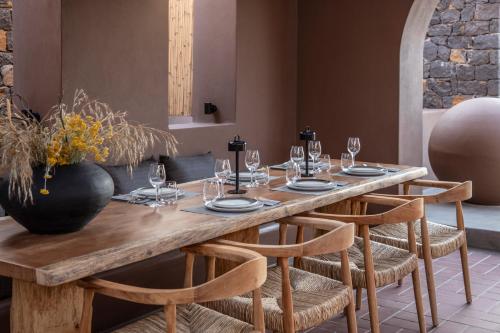 a wooden table with chairs and a dining room at Serra Exclusive Suites in Akrotiri