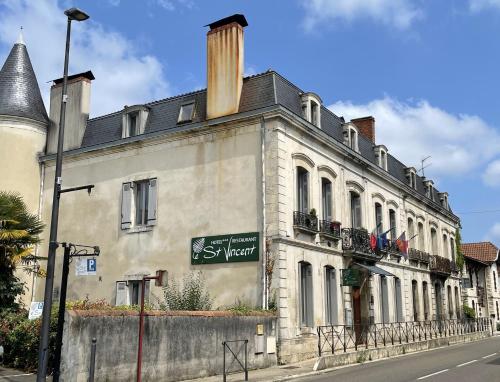 un bâtiment avec un panneau sur son côté dans l'établissement Le St Vincent, à Roquefort