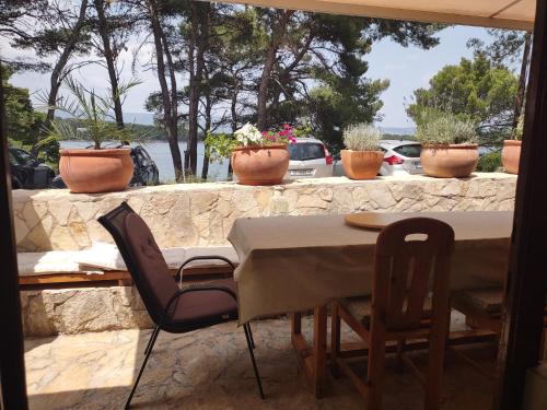 a table and chairs on a patio with potted plants at Stone Villa Hvar Ana Nikola Beach Park and Sea View in Jelsa