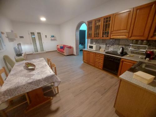 a kitchen with a table and a dining room at VILLA L&M in Floridia