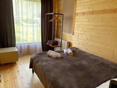 1 dormitorio con 1 cama con 2 toallas en Cottage kazbegi sioni en Stepantsminda
