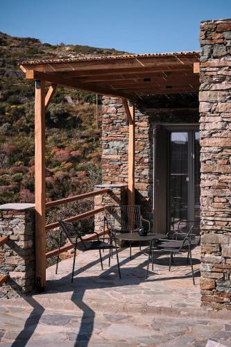 a patio with chairs and a wooden pergola at Sigma Residences Boutique Hotel in Exámbela