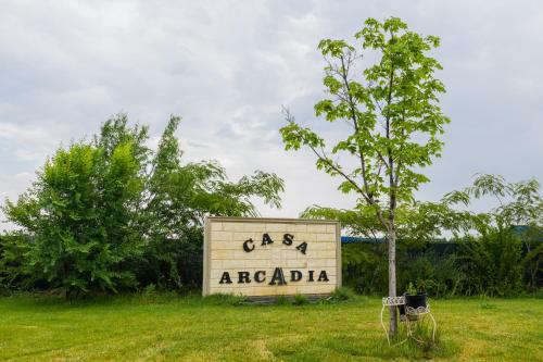a sign forarcadia in a field with a tree at Casa Arcadia 2 piscina,ciubar in Merei