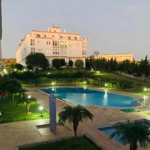 a large swimming pool in front of a large building at Apartamento vacacional achakar playa&piscina! in Tangier