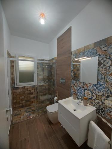 a bathroom with a sink and a toilet and a shower at VILLA L&M in Floridia