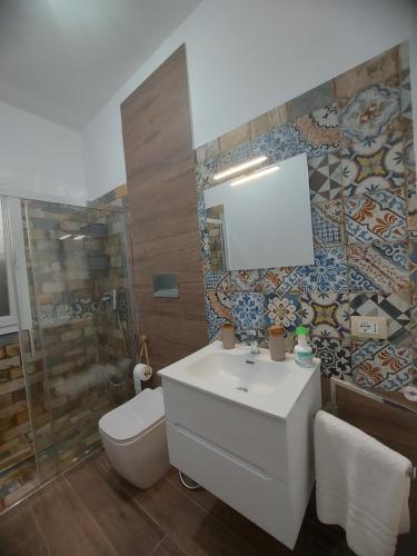 a bathroom with a sink and a shower and a toilet at VILLA L&M in Floridia