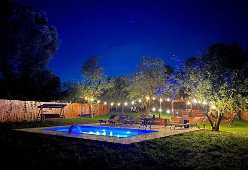 a backyard with a swimming pool at night at Horace Guesthouse POOL & HOT TUB & BIKES & RIVER in Dejani