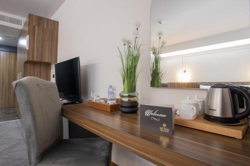 a kitchen with a desk with a coffee maker and a microwave at Bushi Resort & SPA in Skopje