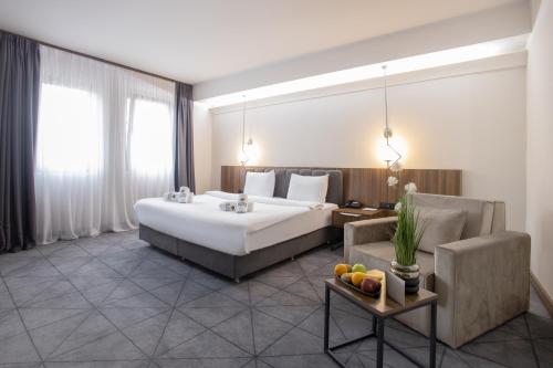 a hotel room with a large bed and a couch at Bushi Resort & SPA in Skopje