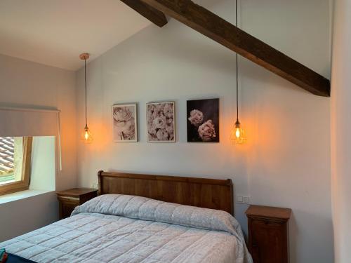 - une chambre avec un lit et trois photos sur le mur dans l'établissement Apartamentos De Montaña Mendiola - Casa Ferran-Casa Karrikaburu, à Valcarlos