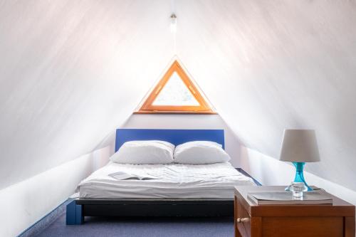 a bedroom with a bed with a triangular window at Willa Bór in Zakopane