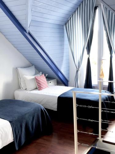 deux lits dans une chambre au toit bleu dans l'établissement Charmante maison entre Marché et Tourelles, à Pornichet