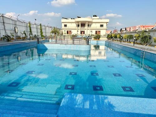 uma grande piscina com água azul em frente a um edifício em Royal Heritage Hotel & Resort em Ayodhya