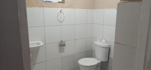 een witte badkamer met een toilet en een wastafel bij Casa de temporada em Petrolina-pe in Petrolina
