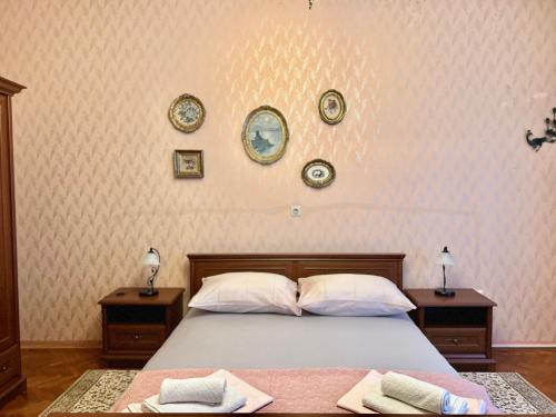 um quarto com uma cama com duas mesas e pratos na parede em Apartman Cinthia em Crikvenica
