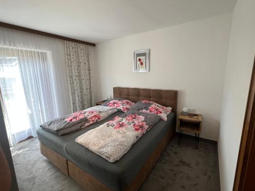 a bedroom with a large bed with flowers on it at Haus Stofleth in Tschagguns