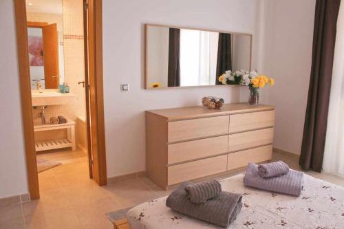 ein Badezimmer mit einer Kommode mit einem Spiegel und Blumen in der Unterkunft Casa Camille Vista al Mar in Costa de Antigua