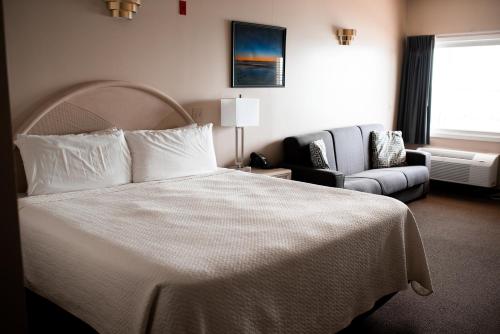 een hotelkamer met een bed en een stoel bij West Bank Inn in Celina